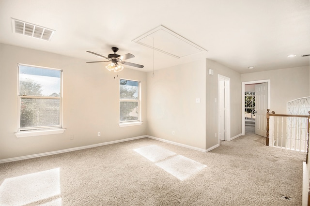 carpeted spare room featuring plenty of natural light and ceiling fan