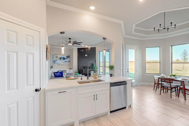 kitchen with sink, stainless steel dishwasher, pendant lighting, white cabinets, and ceiling fan with notable chandelier