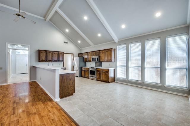 kitchen with beam ceiling, ceiling fan, light hardwood / wood-style floors, and appliances with stainless steel finishes