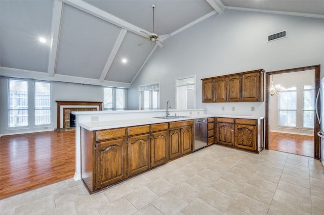 kitchen featuring sink, high vaulted ceiling, stainless steel dishwasher, light hardwood / wood-style floors, and ceiling fan with notable chandelier