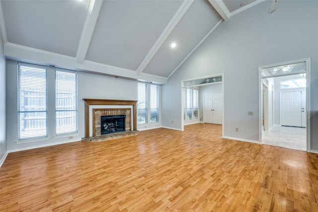 unfurnished living room featuring a fireplace, high vaulted ceiling, light hardwood / wood-style flooring, and beamed ceiling