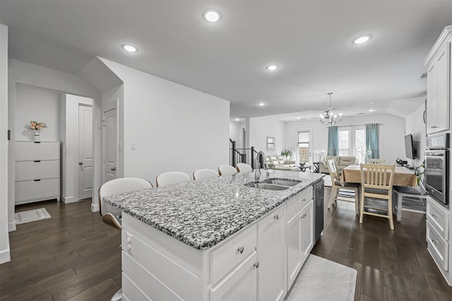 kitchen with white cabinetry, sink, dark stone counters, a kitchen island with sink, and appliances with stainless steel finishes