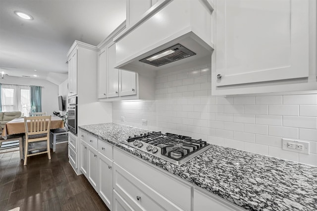 kitchen featuring white cabinets, dark hardwood / wood-style floors, appliances with stainless steel finishes, light stone counters, and custom range hood