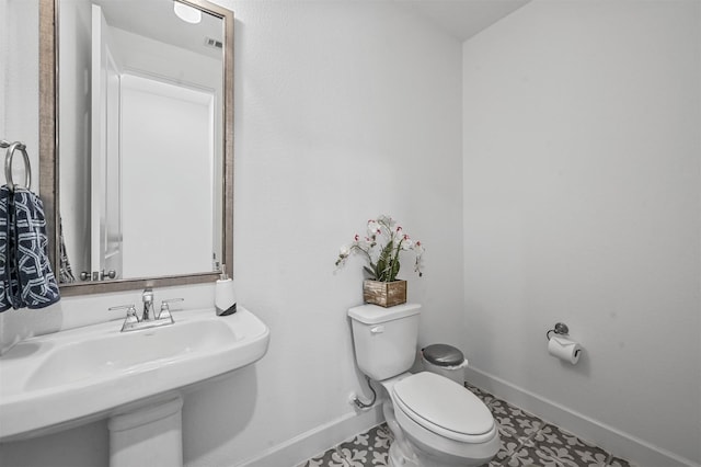 bathroom with tile patterned flooring, toilet, and sink