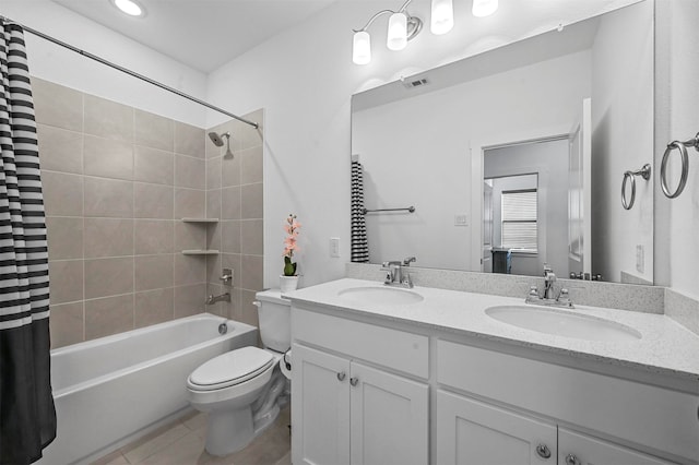 full bathroom with tile patterned floors, shower / bath combo with shower curtain, vanity, and toilet