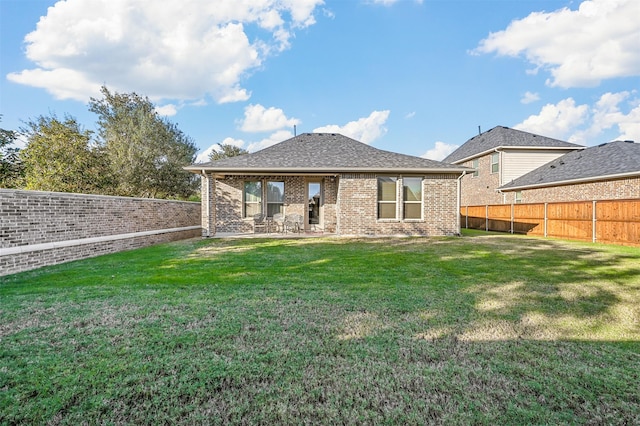 rear view of house featuring a lawn