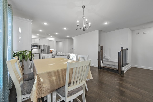 dining space with dark hardwood / wood-style flooring, sink, and an inviting chandelier