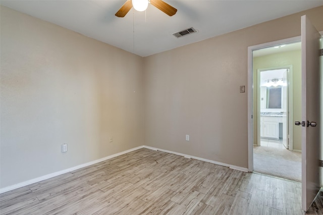 empty room with ceiling fan and light hardwood / wood-style floors