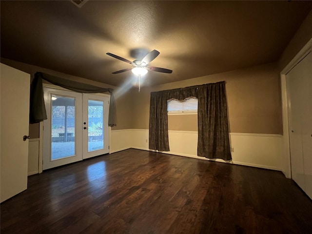 unfurnished room with dark hardwood / wood-style flooring, ceiling fan, french doors, and a textured ceiling