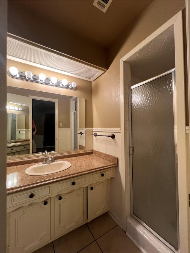 bathroom featuring tile patterned flooring, vanity, and an enclosed shower