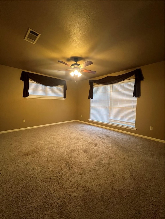 carpeted empty room featuring a textured ceiling and ceiling fan