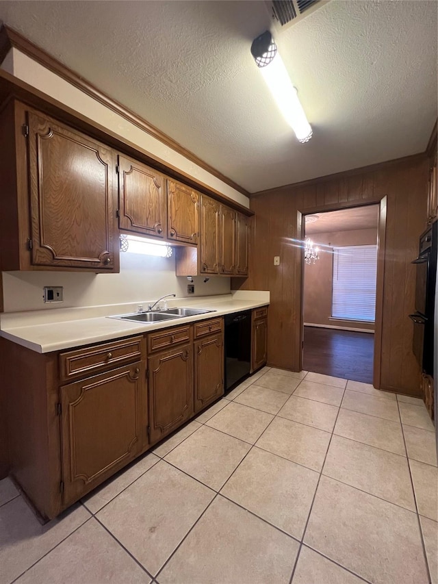 kitchen featuring black appliances, wood walls, light tile patterned floors, and a textured ceiling