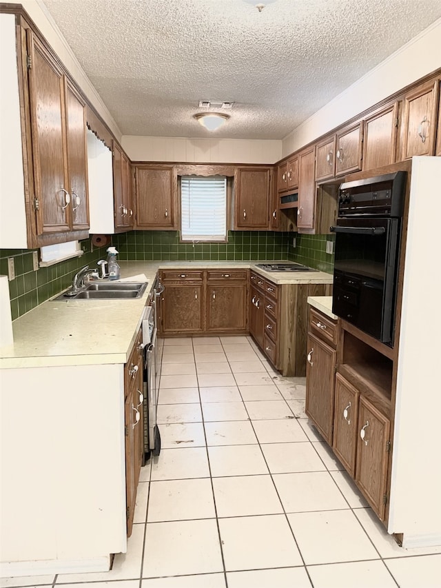 kitchen with sink, stainless steel gas cooktop, backsplash, oven, and light tile patterned flooring