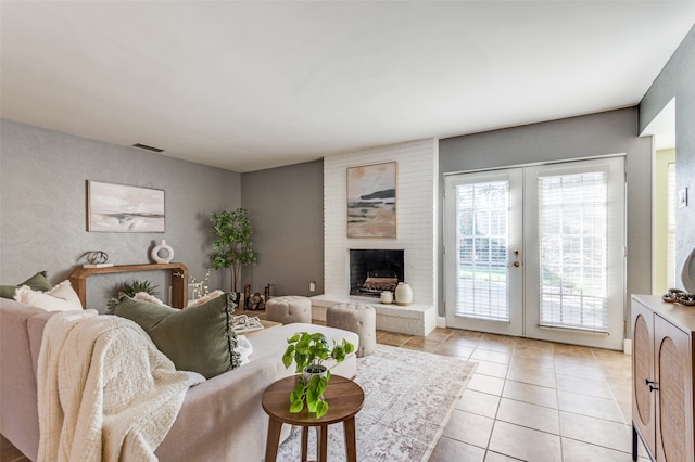 tiled living room featuring a fireplace and french doors