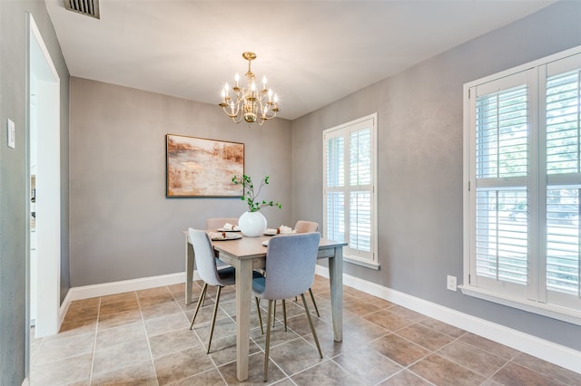 dining area with tile patterned floors, a healthy amount of sunlight, and an inviting chandelier