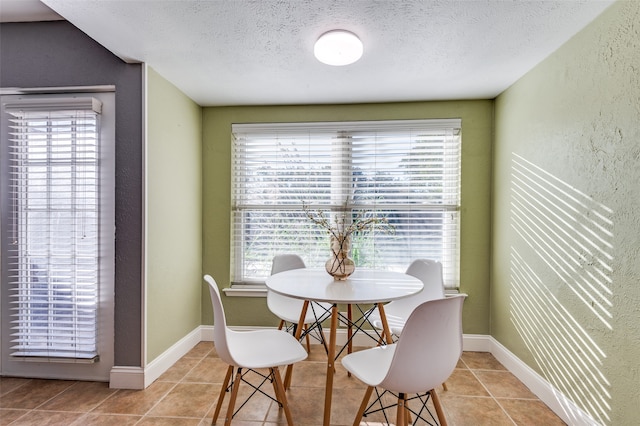 dining room with light tile patterned floors and a textured ceiling