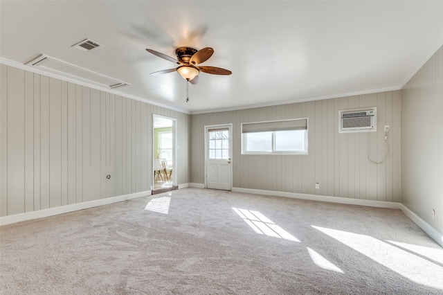 spare room with ceiling fan, crown molding, an AC wall unit, and light carpet