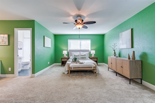 bedroom featuring connected bathroom, light colored carpet, and ceiling fan