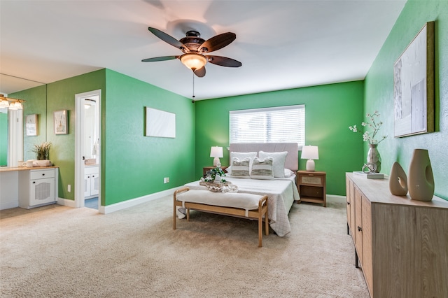 carpeted bedroom with ceiling fan and ensuite bath