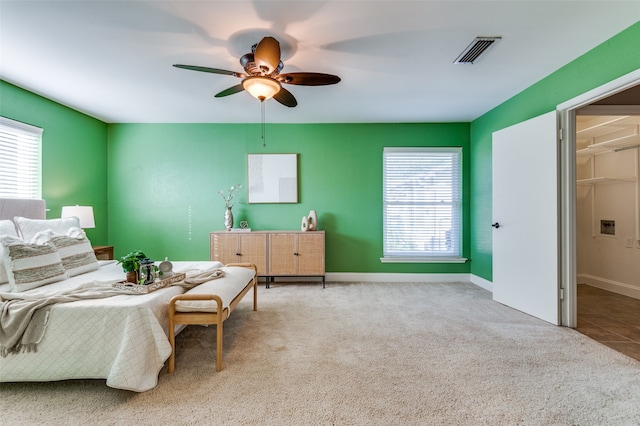 bedroom featuring carpet flooring, a spacious closet, and ceiling fan