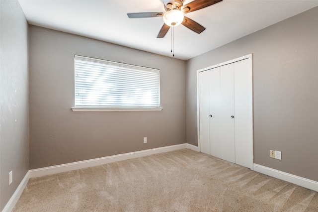 unfurnished bedroom with carpet flooring, ceiling fan, and a closet