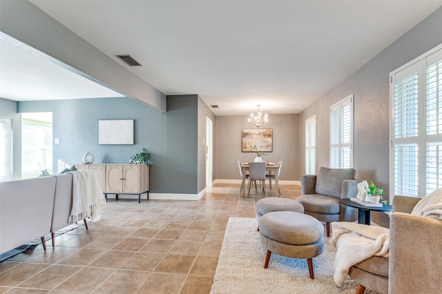 tiled living room with a healthy amount of sunlight and an inviting chandelier