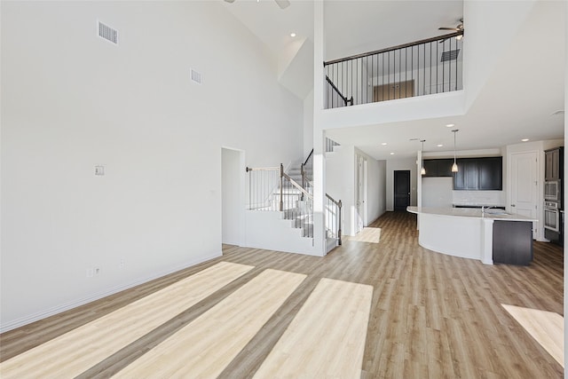 unfurnished living room with hardwood / wood-style flooring and ceiling fan