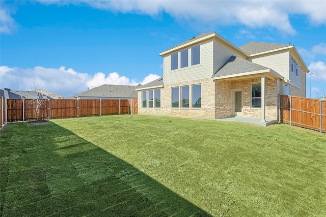 rear view of property with a yard and a patio area