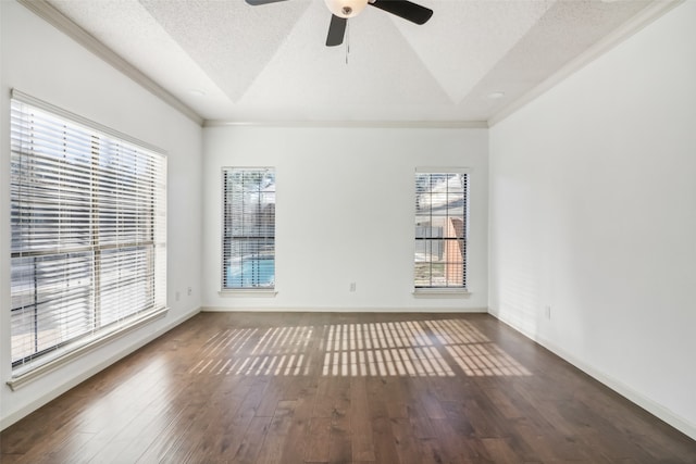 spare room with a textured ceiling, dark hardwood / wood-style floors, plenty of natural light, and ornamental molding