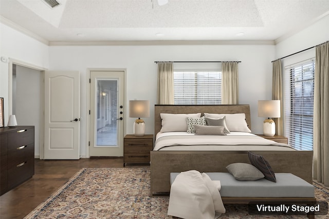 bedroom with dark hardwood / wood-style floors, crown molding, and a textured ceiling