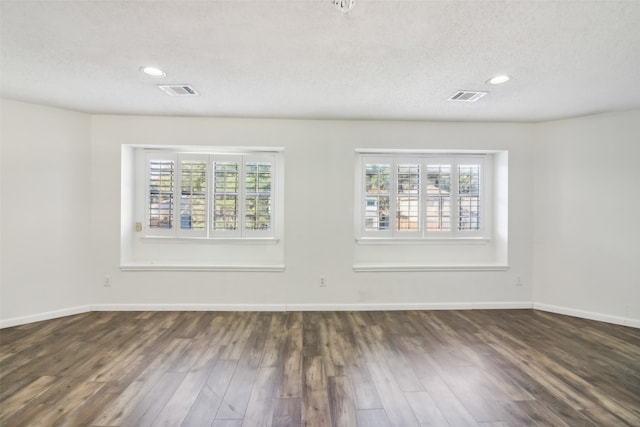 unfurnished room featuring a textured ceiling and dark wood-type flooring