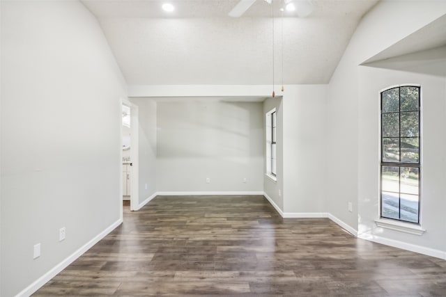 unfurnished room featuring dark hardwood / wood-style floors, ceiling fan, lofted ceiling, and a textured ceiling