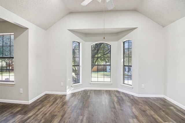 unfurnished dining area with a textured ceiling, dark wood-type flooring, and vaulted ceiling