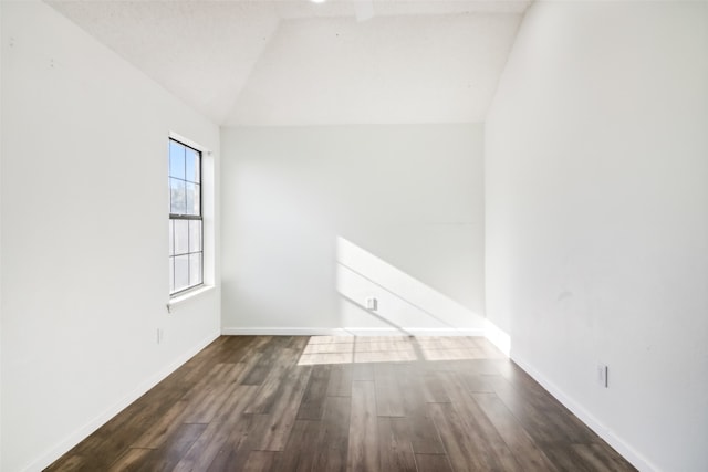 unfurnished room with dark wood-type flooring and lofted ceiling