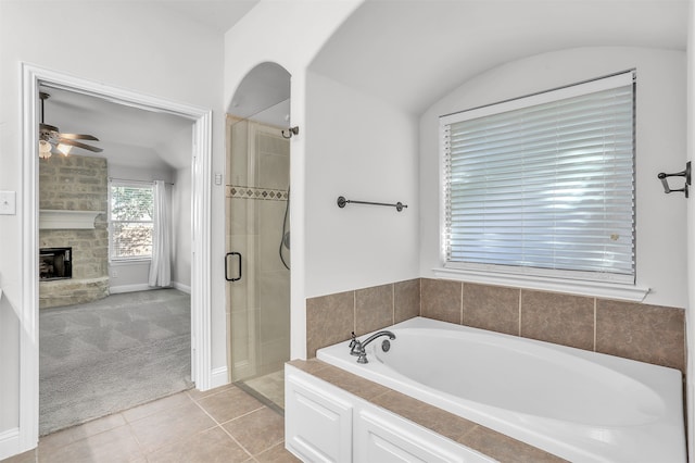 bathroom with a fireplace, ceiling fan, tile patterned floors, and independent shower and bath