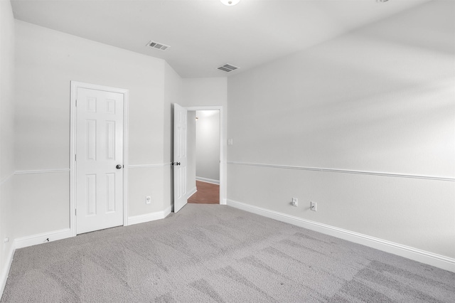 empty room with vaulted ceiling and carpet