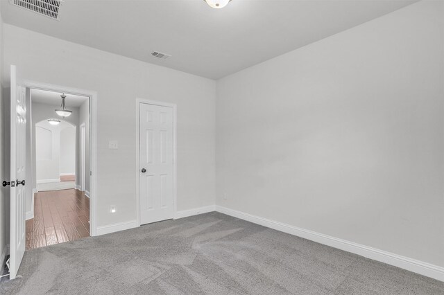 carpeted empty room featuring vaulted ceiling