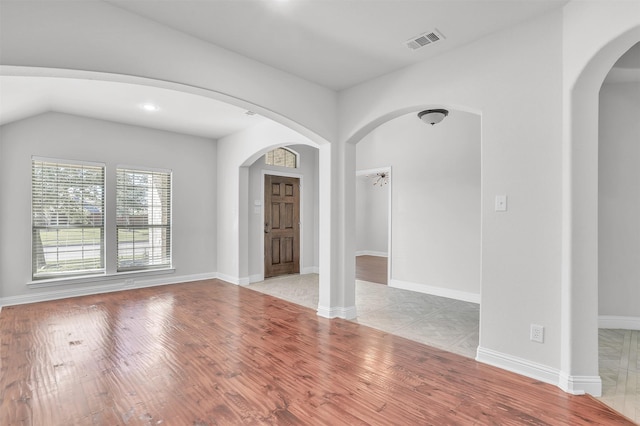 foyer entrance with lofted ceiling and light hardwood / wood-style flooring