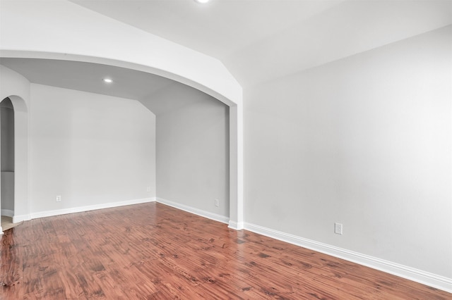 spare room with hardwood / wood-style floors and lofted ceiling