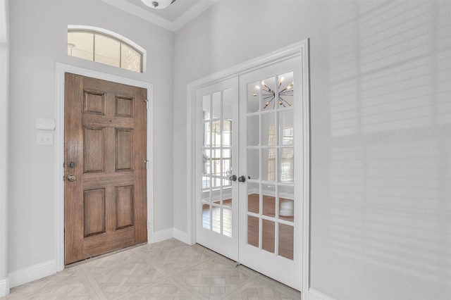 entrance foyer with french doors, a chandelier, light parquet floors, and crown molding