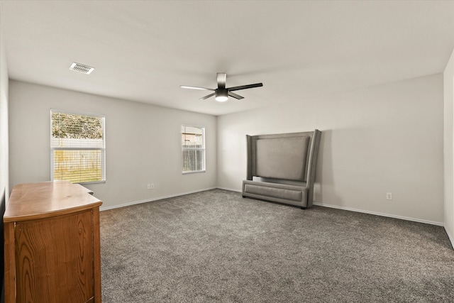 spare room with dark colored carpet and ceiling fan