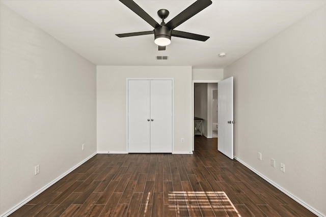 unfurnished bedroom featuring dark hardwood / wood-style floors, ceiling fan, and a closet