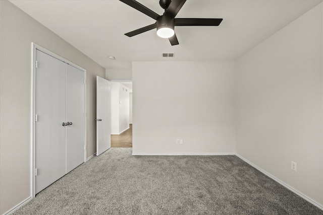 unfurnished bedroom with carpet flooring, ceiling fan, and a closet