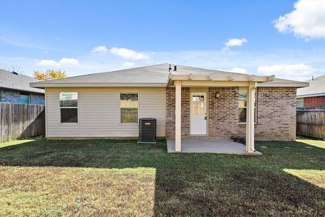 rear view of house with a yard, cooling unit, and a patio