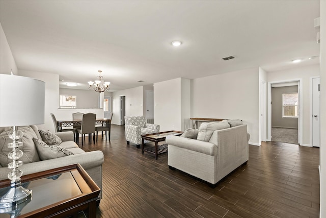 living room with dark hardwood / wood-style flooring and a chandelier