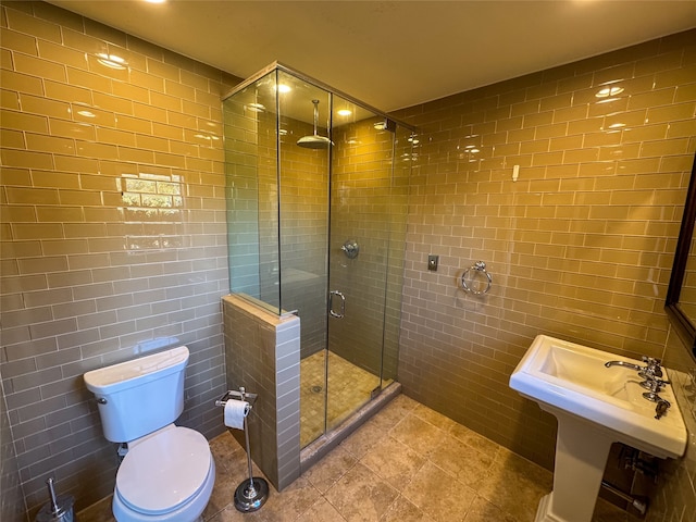 bathroom featuring tile patterned flooring, toilet, walk in shower, and tile walls