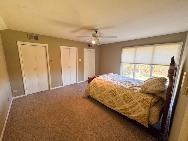 carpeted bedroom with two closets and ceiling fan