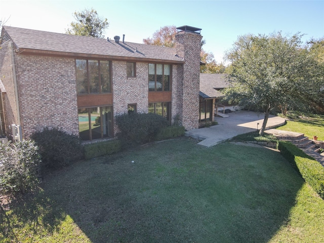 back of house featuring a lawn and a patio area