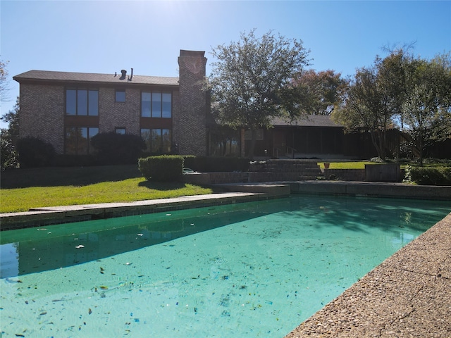 view of swimming pool with a yard