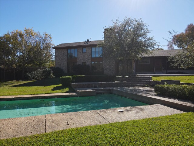 view of swimming pool with a lawn